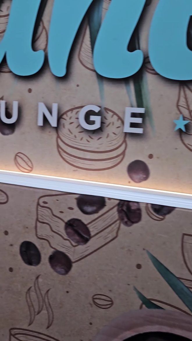 Detail of the beige wall mural of coffee cups and cakes (cropped to exclude the script lettering)