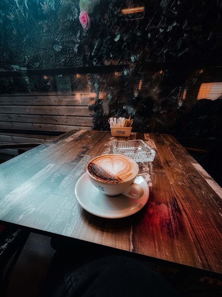 A cappuccino with latte art, shot close on a dark wooden table